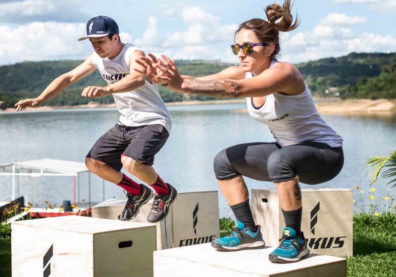 Imagem de dois atletas praticando exercícios físicos ao ar livre
