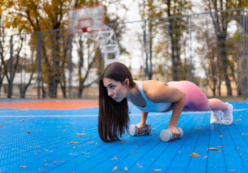 Imagem de uma atleta treinando funcional ao ar livre